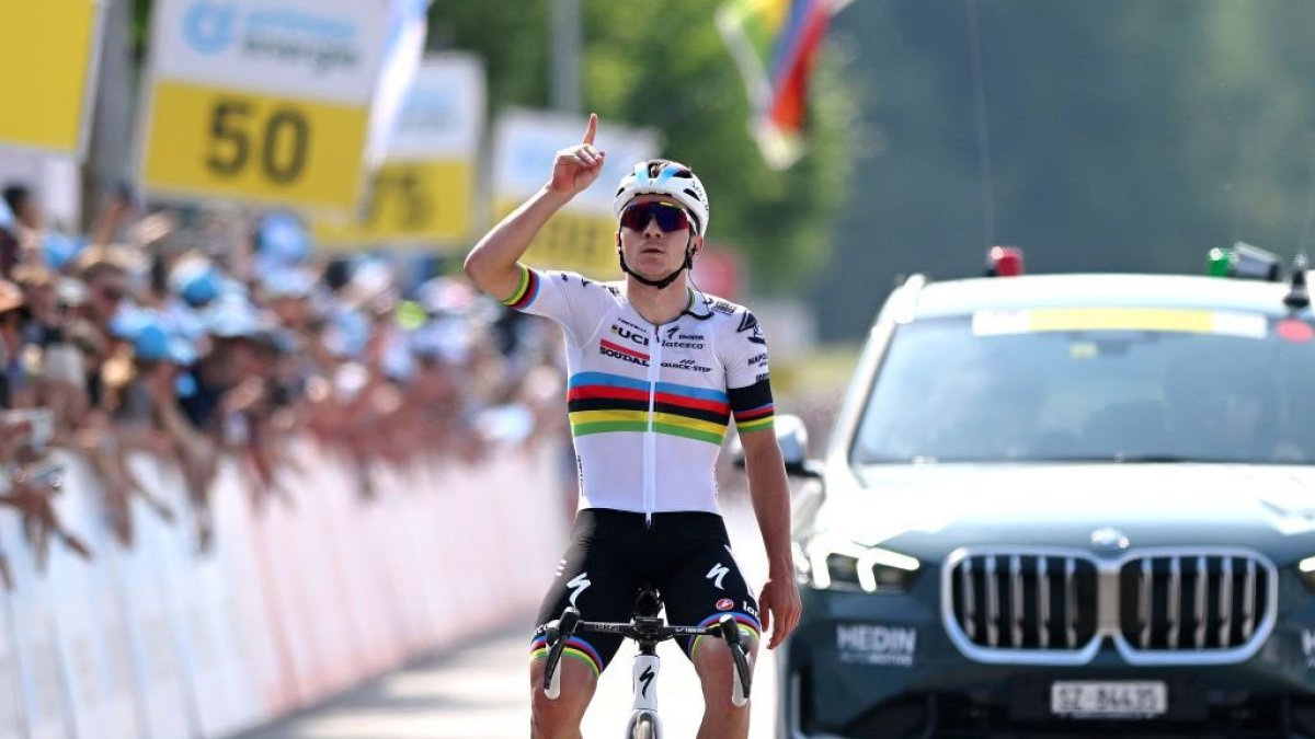 Evenepoel llegando a la meta mientras apuntaba al cielo en honor al ciclista fallecido.
