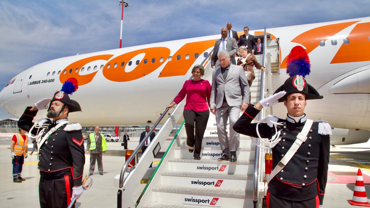 El presidnte de Cuba Miguel Díaz-Canel mientras desciende del avión junto a su esposa, la primera dama Lis Cuesta, tras aterrizar en Roma (Italia).  