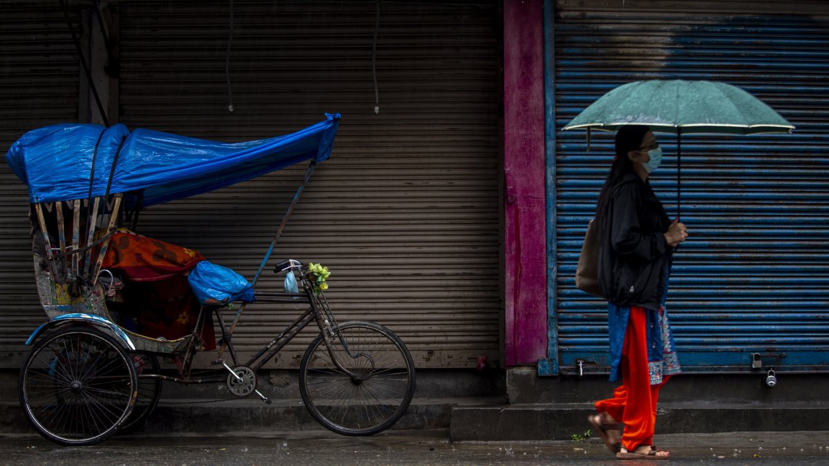 una mujer caminando bajo la lluvia en Kathmandu (Nepal).