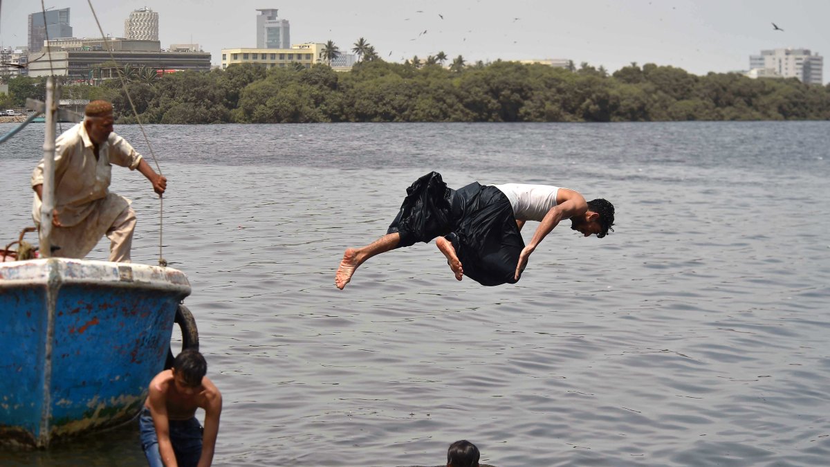 Unos chicos sse refrescan tras una sofocante ola de calor