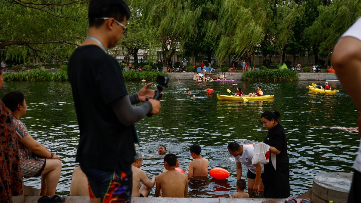 La gente se refresca a lo largo de un canal en Beijing, China, el 23 de junio de 2023. Beijing registró el 22 de junio el día más caluroso de junio con 41,1 grados centígrados.