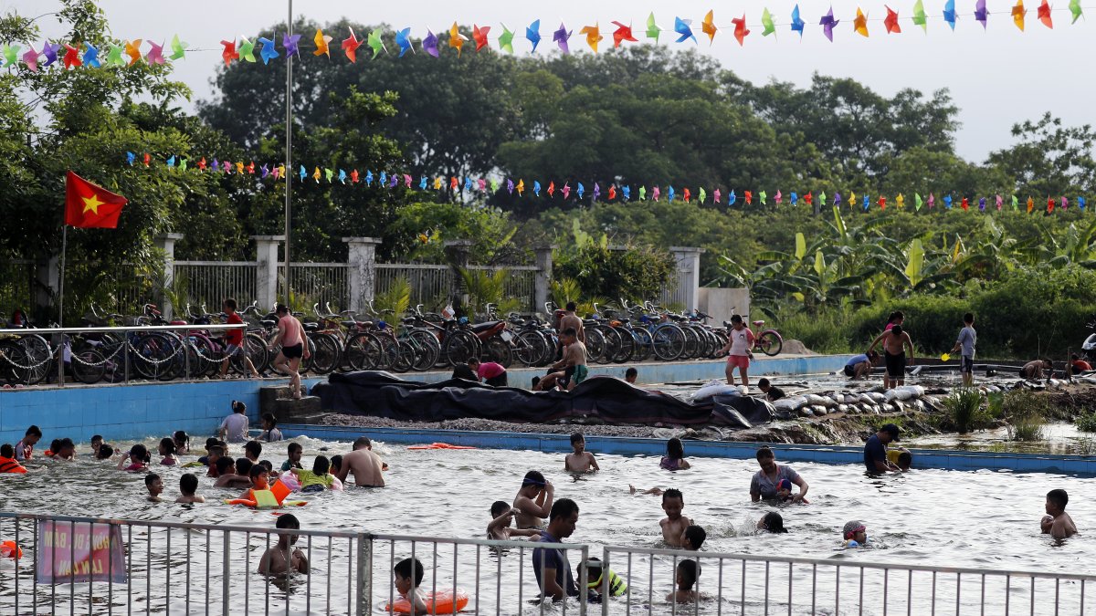 Un grupo de personas se refrescan en una psicina ante la ola de calor.