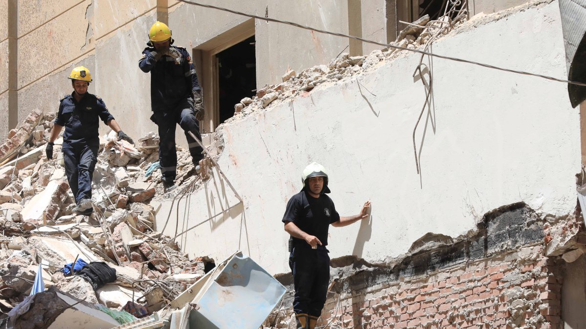Personal de protección civil busca supervivientes entre los escombros de un edificio de 14 plantas derrumbado en Alejandría, Egipto, el 26 de junio de 2023