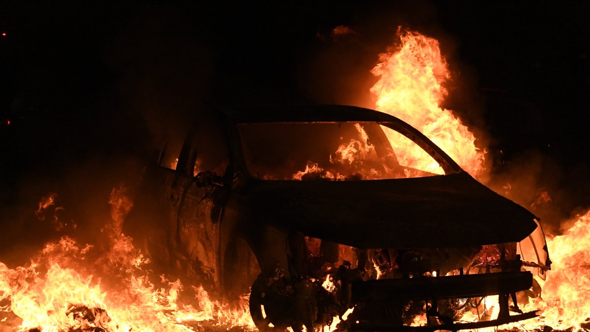 Un automóvil arde durante enfrentamientos entre manifestantes y policías antidisturbios en Nanterre, cerca de París, Francia, el 29 de junio de 2023