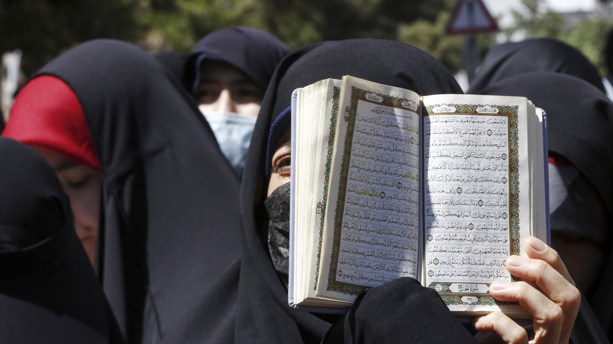 Una mujer iraní sostiene un ejemplar del libro sagrado del Corán mientras se manifiestan frente a la embajada de Suecia en Teherán, Irán, el 30 de junio de 2023.