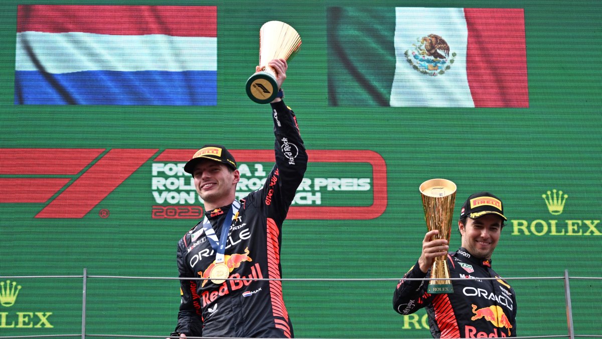 El piloto holandés Max Verstappen (i) de Red Bull Racing, primer clasificado, y el tercer clasificado, su compañero mexicano Sergio Pérez (R), celebran con los trofeos en el podio del GP de Austria.