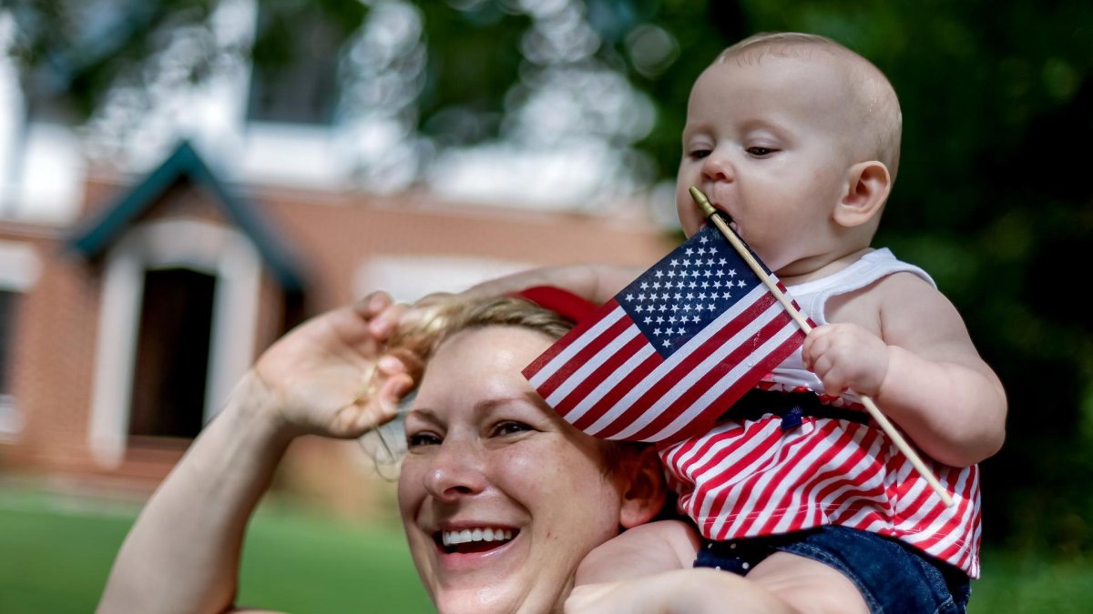 Jillian Ward sostiene a su hija Saoirse, de seis meses, durante el Desfile del 4 de julio en el Día de la Independencia de los Estados Unidos en Avondale Estates, Georgia, EE.UU.