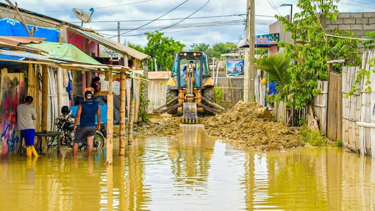 Proceso. Maquinaria intenta despejar una vía que no tiene asfalto.