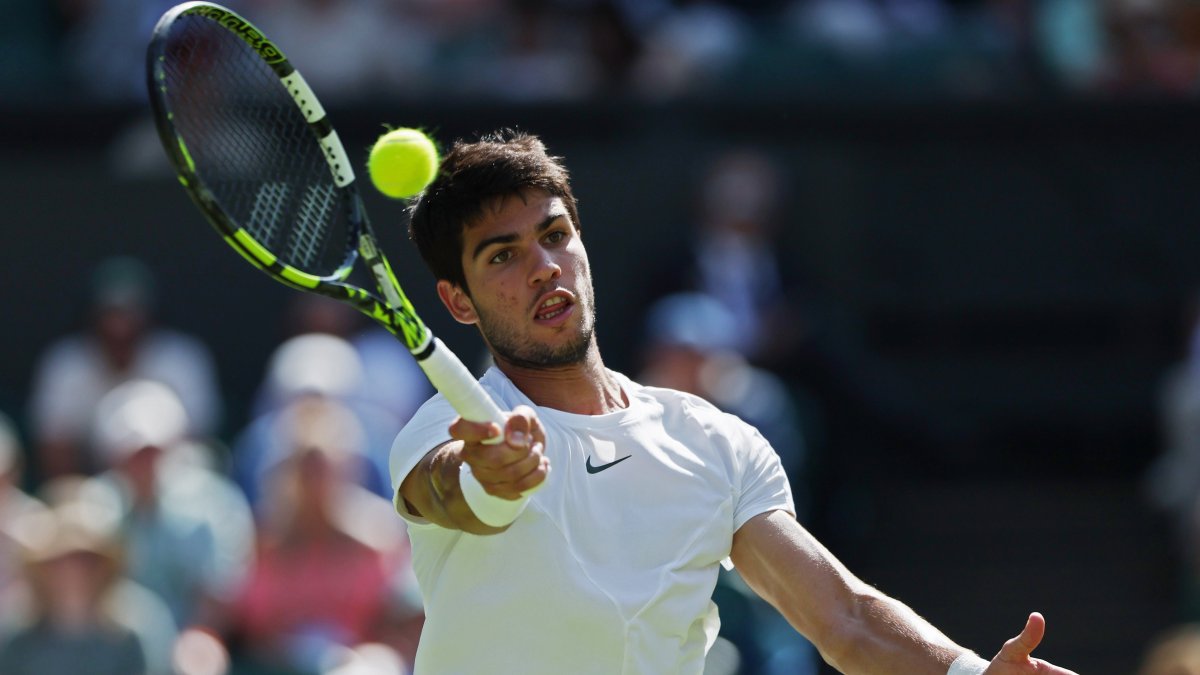El tenista español Carlos Alcaraz devuelve una bola durante su partido ante el francés Alexandre Muller, de segunda ronda del torneo de Wimbledon este viernes.