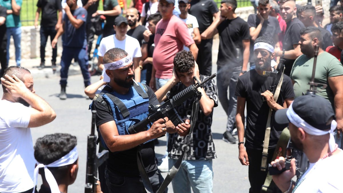 Un militante palestino dispara al aire mientras asistía al funeral de los dos hombres muertos durante una redada israelí en la ciudad de Nablus.