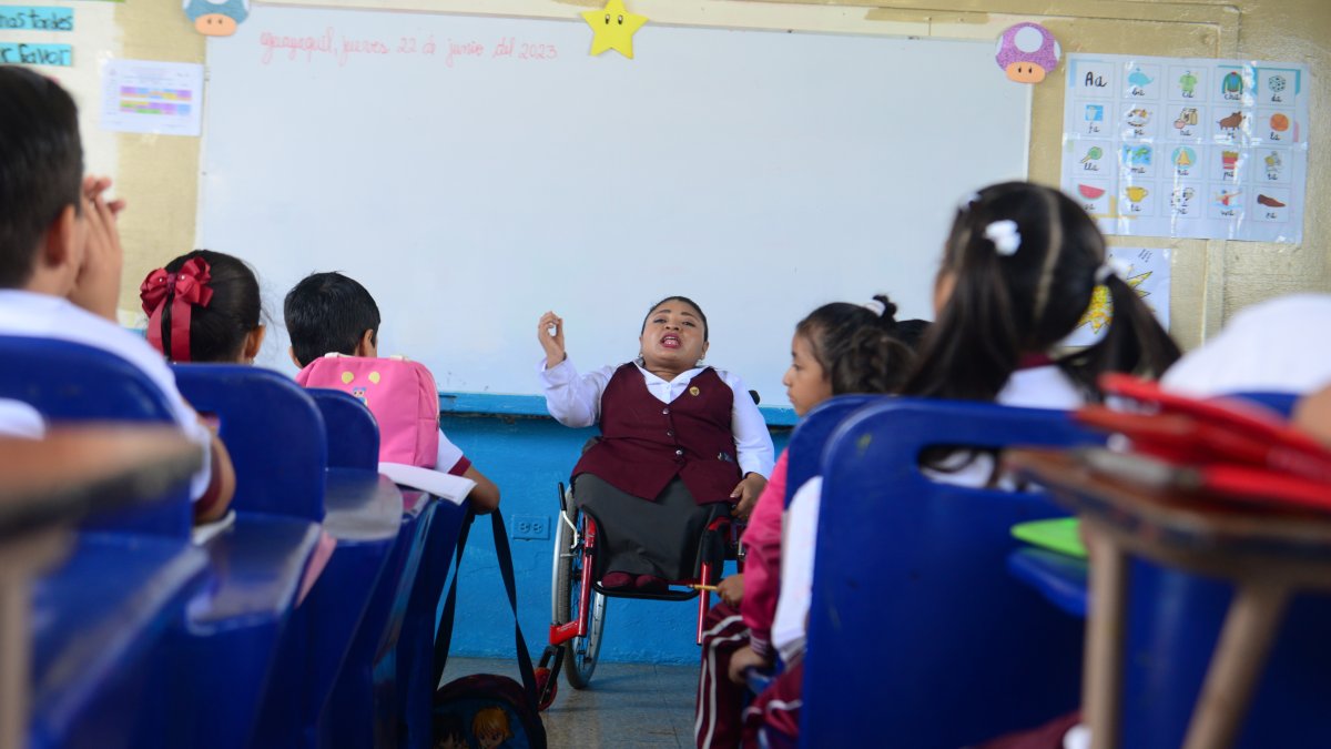 Dedicación. Sobre su silla de ruedas, la maestra Clara Celi imparte enseñanza a los estudiantes de la escuela fiscal Benjamín Rosales.