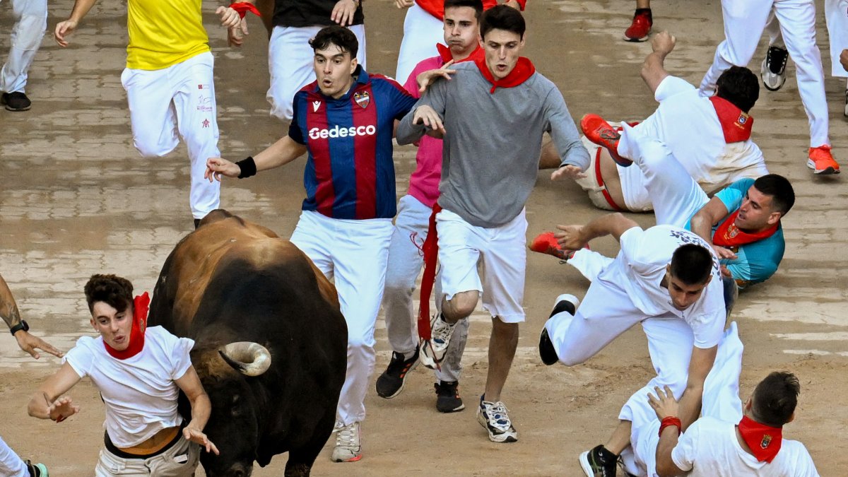 Un mozo es arrollado por uno de los toros de la ganadería de Fuente Ymbro en su entrada a la plaza de toros de Pamplona, el lunes 10 de julio.