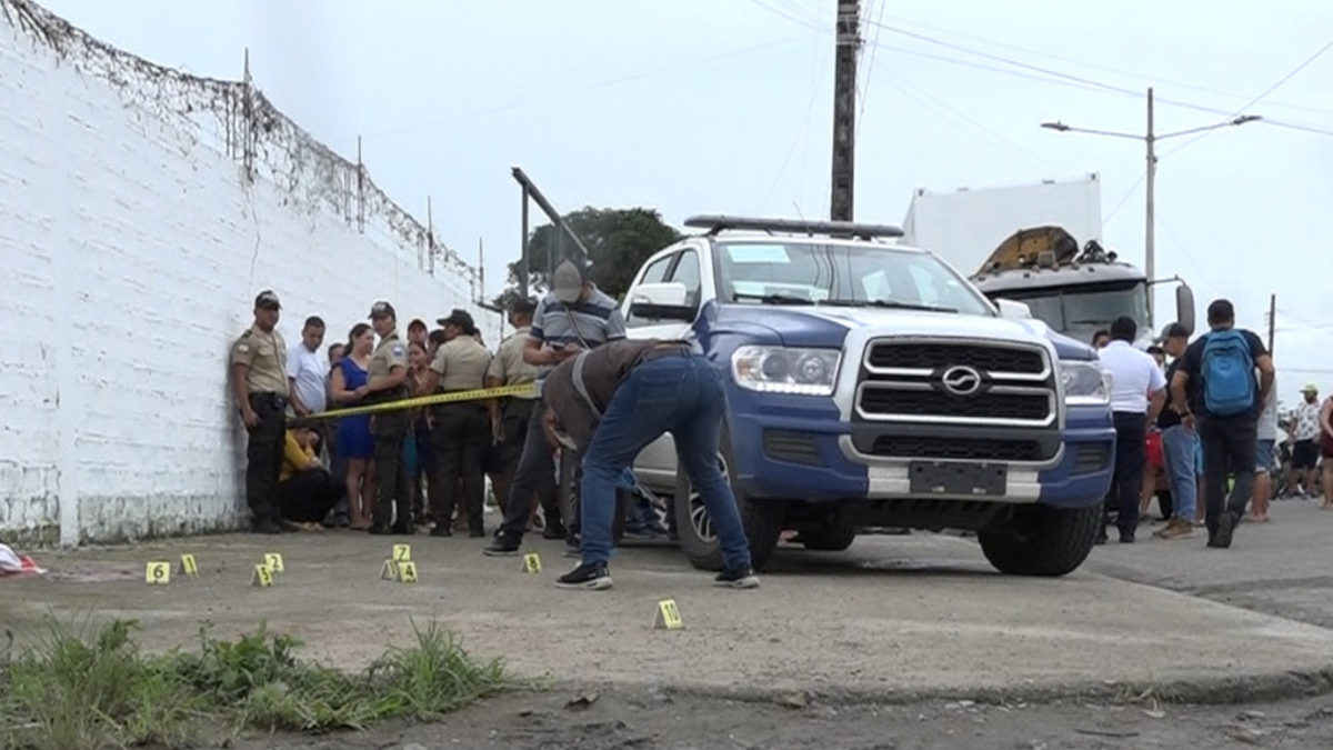Agentes de Criminalística recogiendo indicios en un sector de Naranjal.