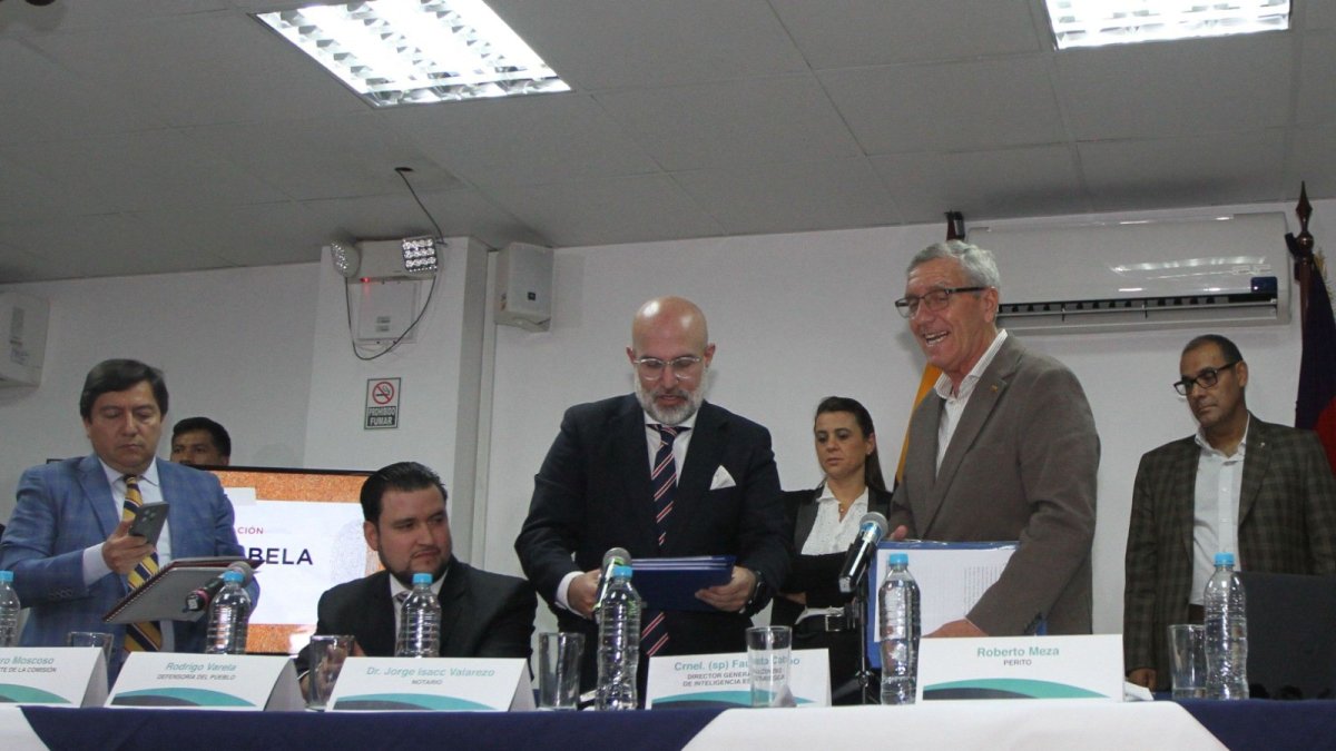 Acto. Fausto Cobo y Arturo Moscoso, durante la entrega del informe a Patricia Ochoa, viuda de Gabela.