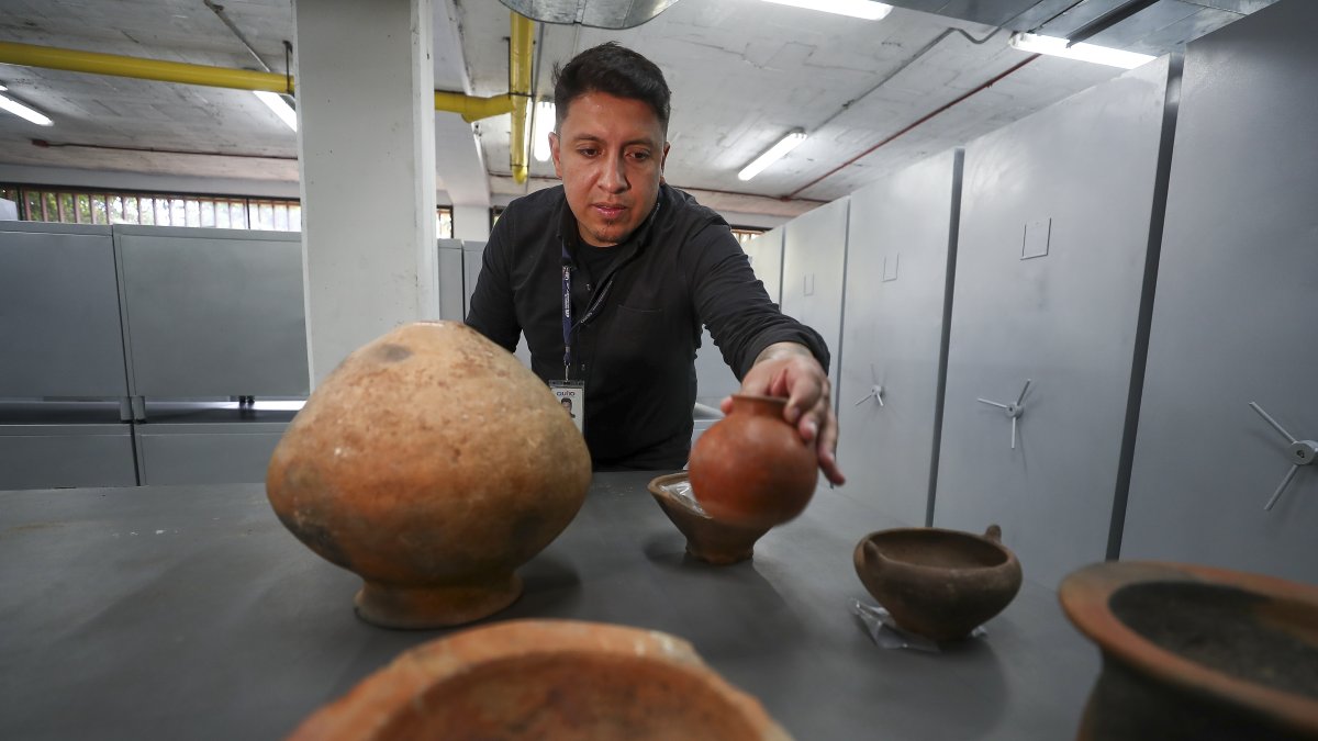 El arqueólogo Andrés Mosquera enseña parte de las piezas talladas el 13 de julio de 2023 en Quito (Ecuador).