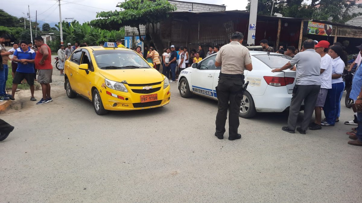 Policías y colegas de los taxistas asesinados en un sector del centro de Naranjal.
