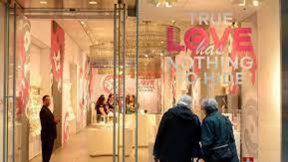 Tienda.- Una pareja observa relojes en un almacén, que en la vitrina dice que el verdadero amor no tiene nada que esconder.