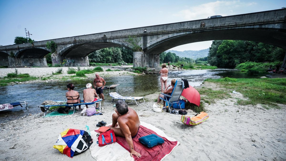 Turineses combaten el calor a orillas del río Orco. El hemisferio norte, que apenas lleva un mes bajo el solsticio de verano, se asfixia bajo unas temperaturas diurnas de récord y un calor nocturno.