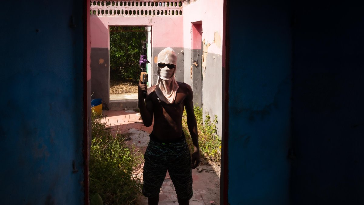 Sitio. Un miembro de una pandilla sostiene un arma, en Puerto Príncipe.