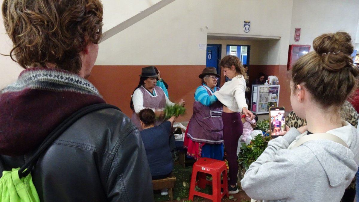 Cuenca. Un grupo de turistas experimenta con una sesión de cura en el tradicional mercado 10 de Agosto.