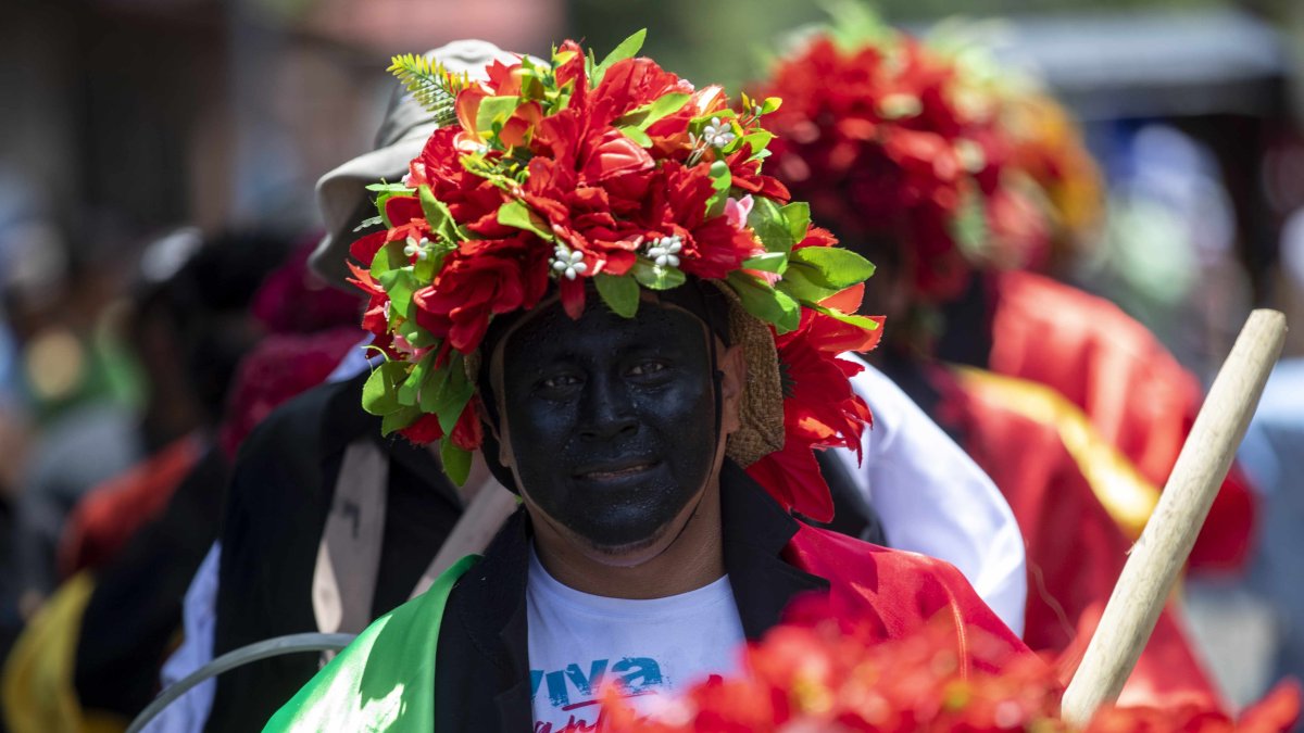 Un hombre disfrazado participa del tradicional baile de los chinegros en honor a Santa Ana.