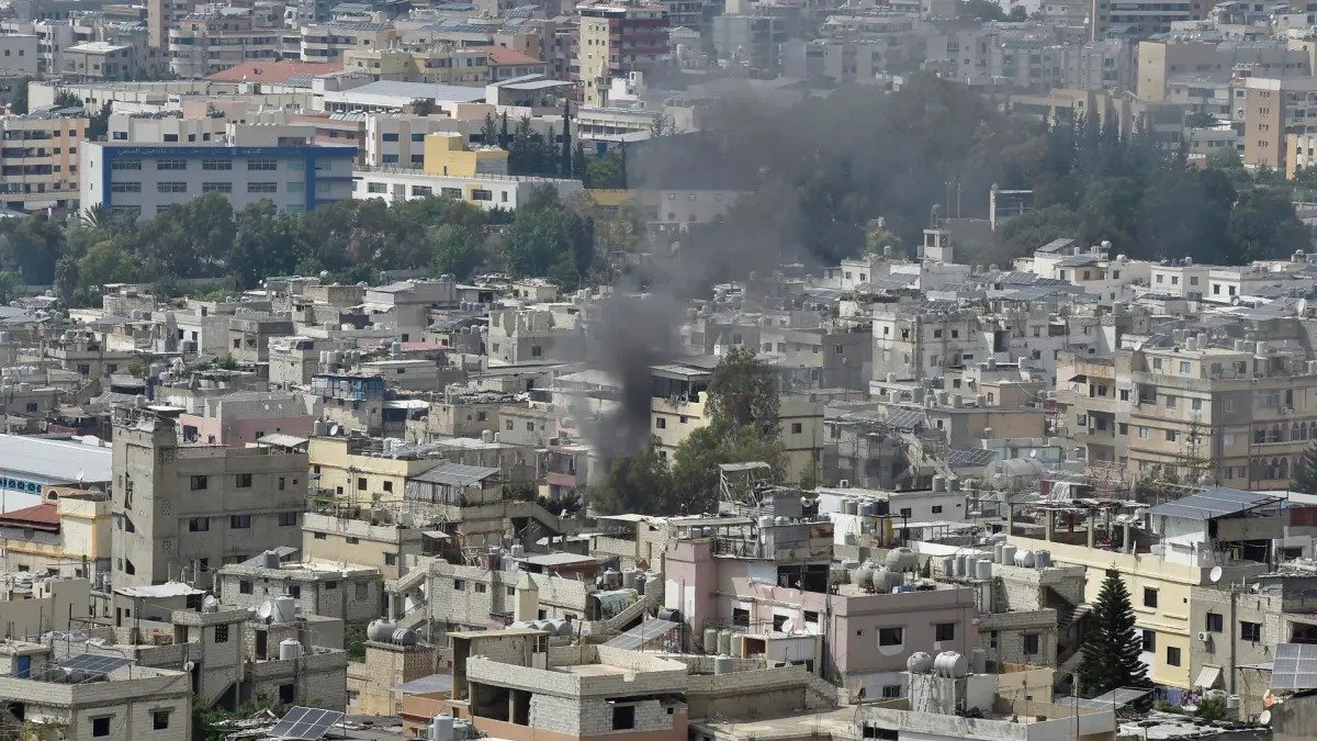 Una columna de humo en el campamento de refugiados de Ain el Helu, en la ciudad de Sidón, donde facciones palestinas se enfrentan hoy por tercer día consecutivo.