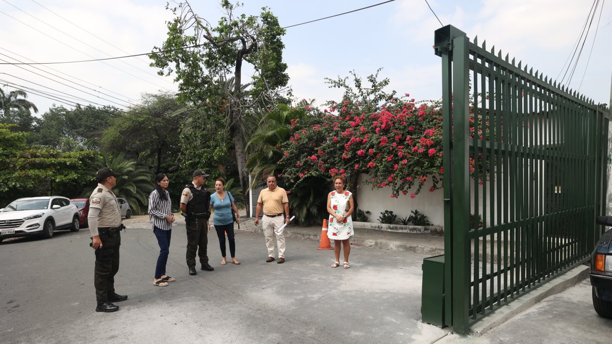 Residentes, acompañados por la Policía, muestran los portones que se han colocado en el malecón de la ciudadela Miraflores.