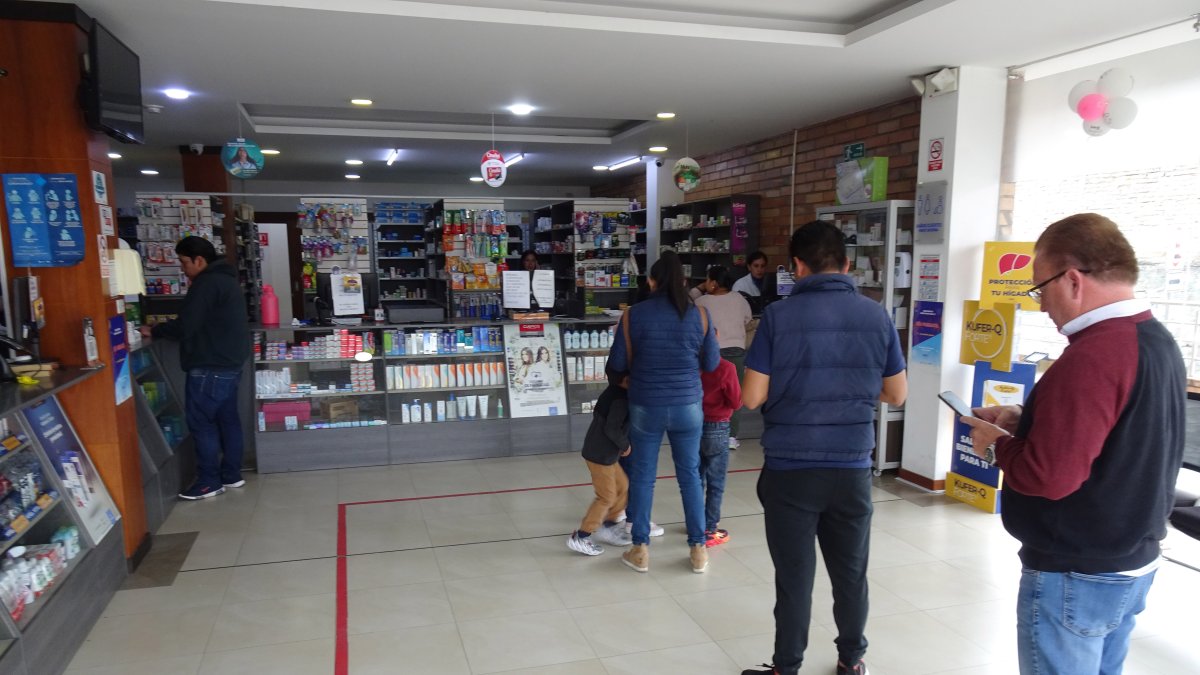 En Cuenca, un grupo de usuarios espera su turno en una farmacia de la empresa municipal Farmasol.