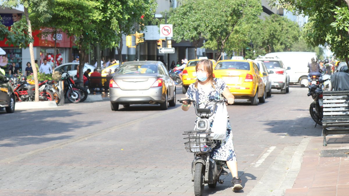Una mujer maneja una moto en contravía en plena avenida 9 de Octubre, de Guayaquil.