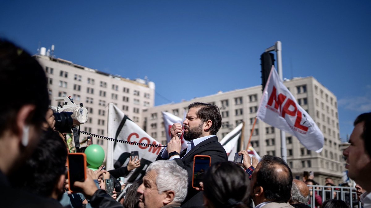 Gabriel Boric, mientras habla a manifestantes que protestan a favor del derecho a la vivienda digna, hoy jueves 10 de agosto, a las afueras del palacio La Moneda, en Santiago (Chile)