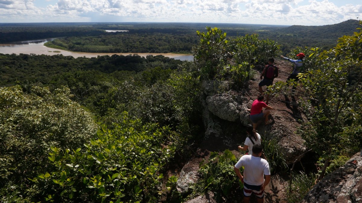Paisaje. Varios turistas observan desde un mirador el curso del río Raudal del Guayabero, en la región del Guaviare (Colombia).