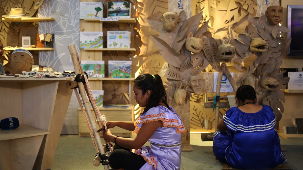 Mujeres tacanas realizan tejidos típicos de artesanías durante la Feria Internacional del Libro, el 9 de agosto de 2023, en La Paz (Bolivia).