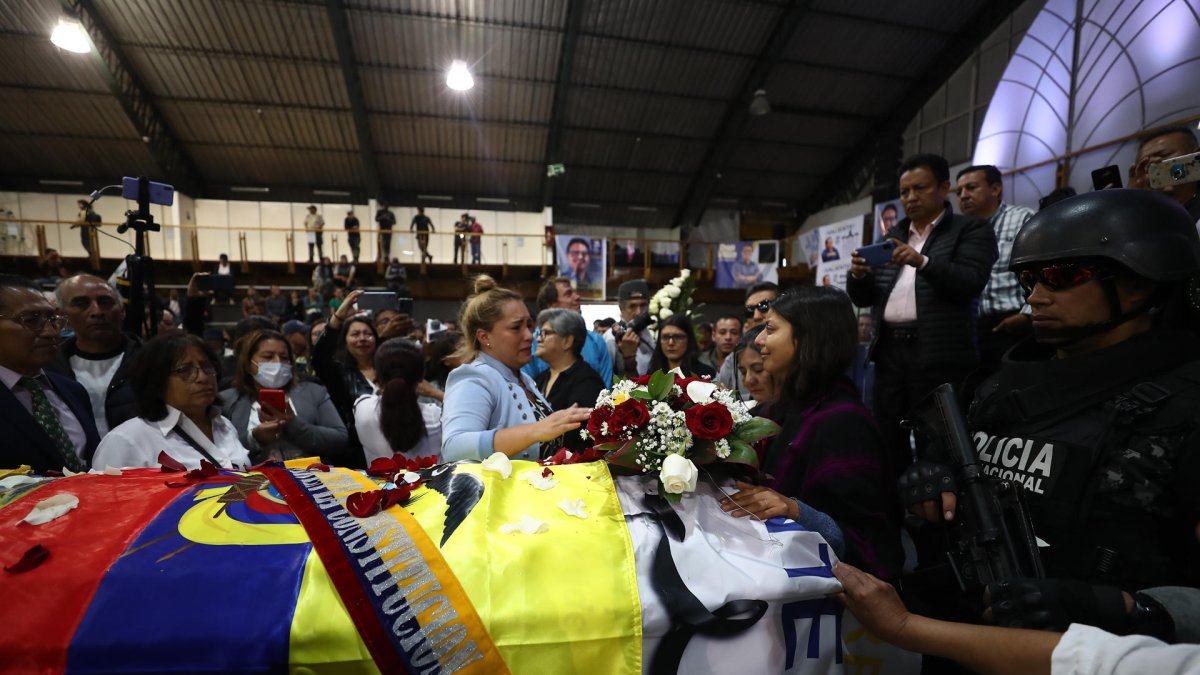 Simpatizantes muestran sus respetos ante el féretro del candidato Fernando Villavicencio, durante un velatorio público en el Centro de Exposiciones, en Quito (Ecuador).
