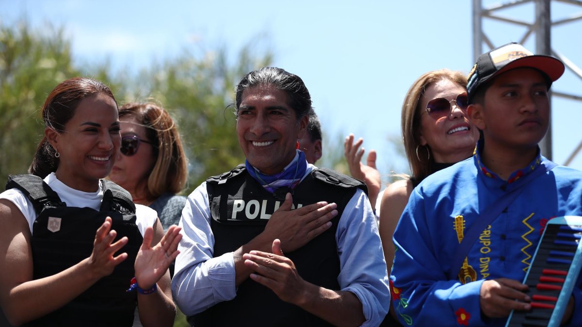 El candidato a la Presidencia de Ecuador Yaku Pérez (d) ondea una bandera de Ecuador durante su cierre de campaña hoy, en Quito (Ecuador).