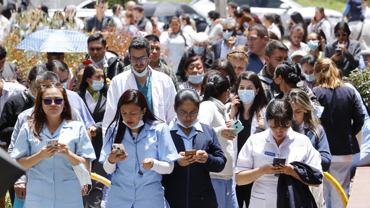 Personas se reúnen afuera de un edificio luego de ser evacuadas debido a un sismo de 6.1 hoy, en Bogotá (Colombia). 