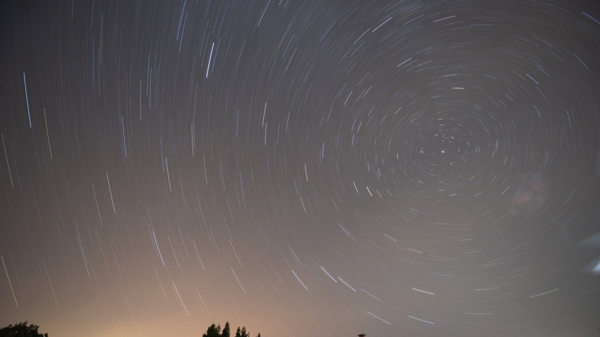 Fotografía de larga exposición durante la lluvia de estrellas de las Perseidas sobre la localidad cántabra de Comillas.