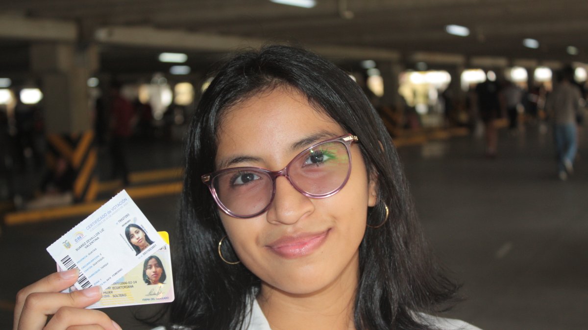 Liz Suárez, de 17 años, quien sufragó por primera vez, muestra su cédula y certificado de votación.