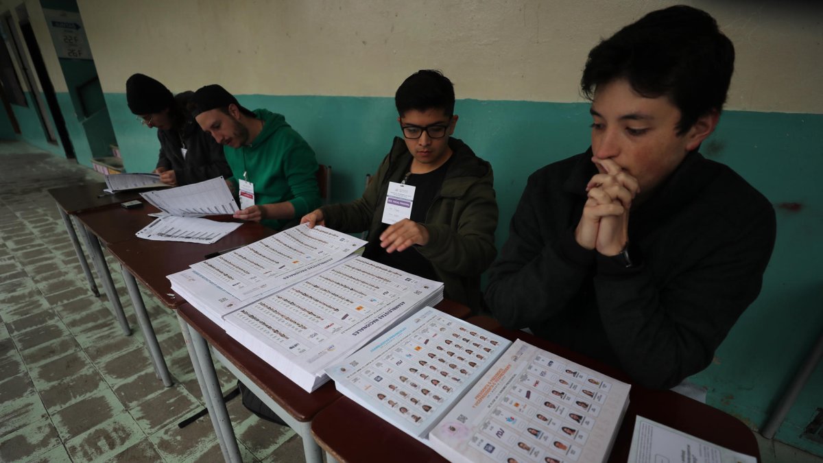 Jurados y trabajadores electorales preparan la apertura de los centros de votación para la jornada de elecciones presidenciales, en Quito.