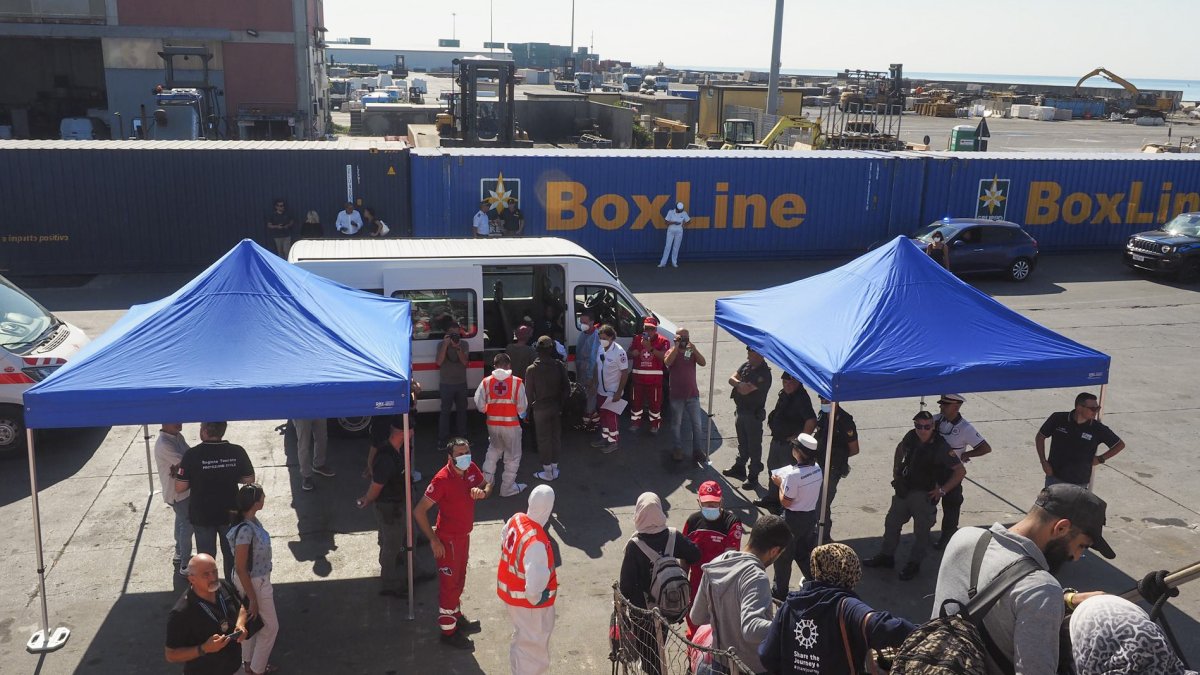 Los 195 migrantes rescatados desembarcan del Open Arms, este martes en Marina de Carrara (Italia), antes de ser repartidos entre las regiones de Piamonte, Toscana y Umbría.