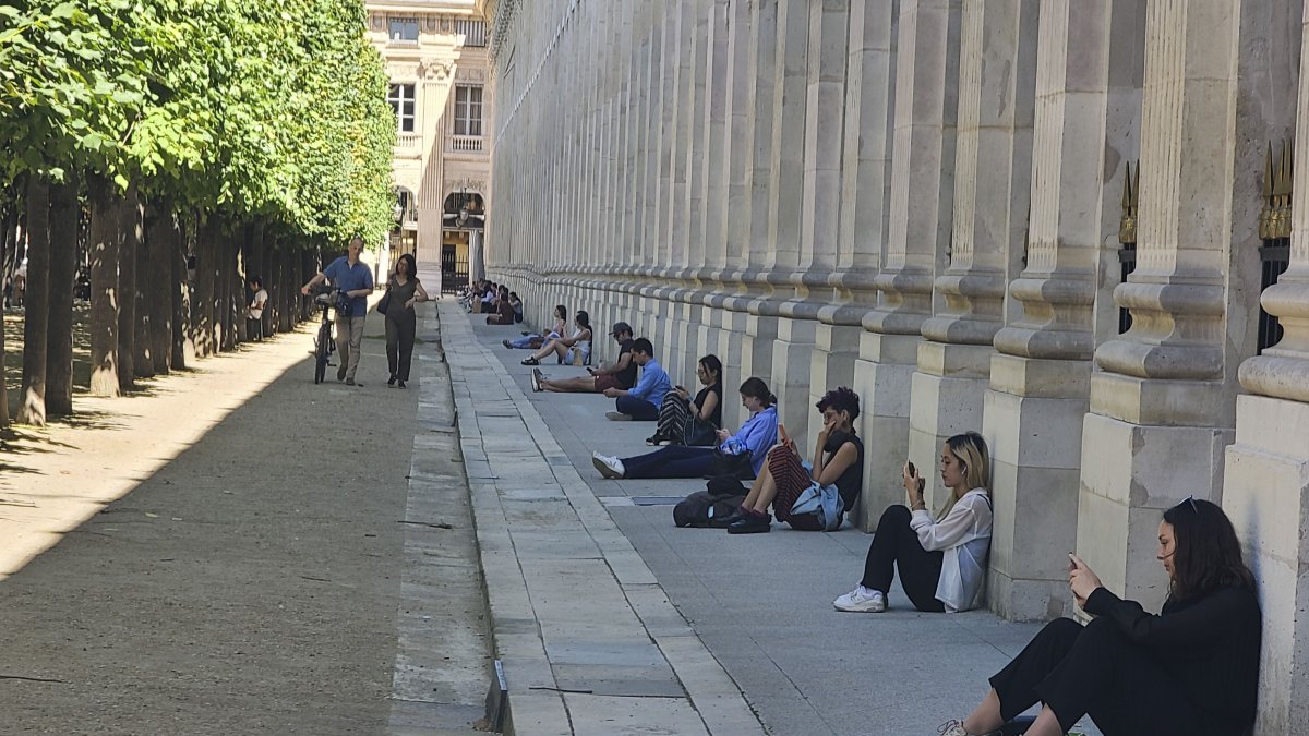 En la imagen, un grupo de personas se refugia del calor este lunes en las inmediaciones del jardín del Palacio Real de París.
