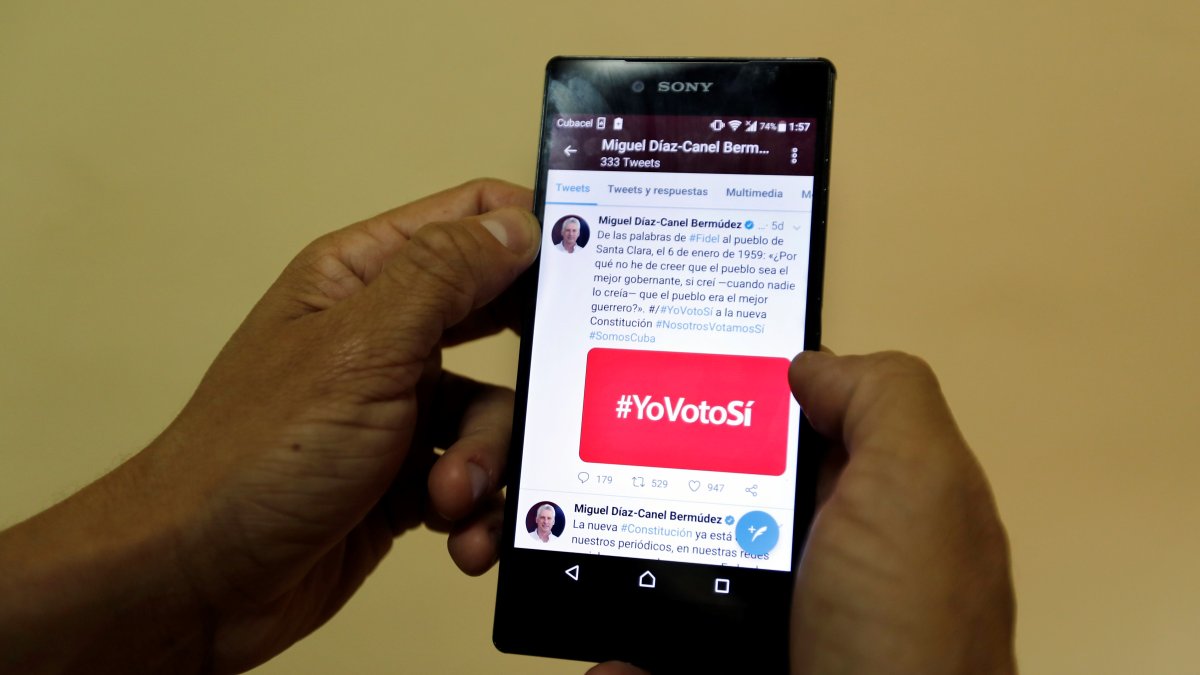 Tendencias. Una persona muestra la pantalla de su móvil con un hashtag relativo a un tema político.