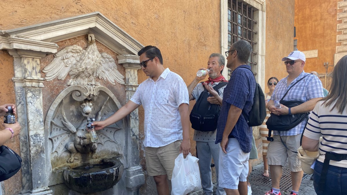 Turistas beben en una fuente, este viernes en Roma.