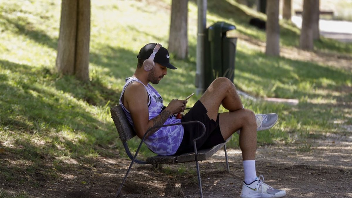 Un hombre descansa en la sombra de un parque en Madrid