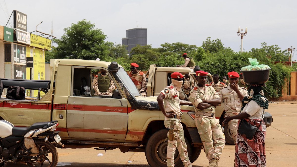 Soldados hablan con una mujer en los exteriores de un estadio en Niamey, Niger.