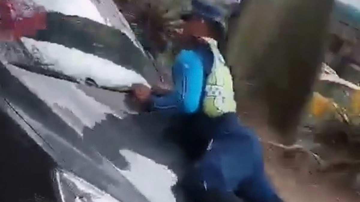 En el video queda registrado el instante en el que el agente era llevado sobre el capó.