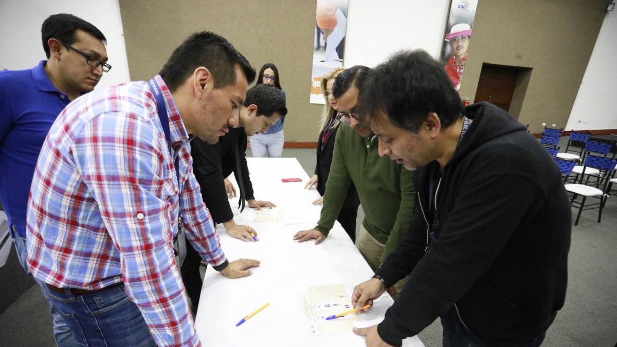 CNE junto a delegados de los movimientos políticos verificando la papeleta electoral.