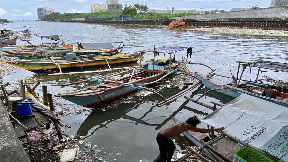 Un pescador fue registrado este 28 de agosto al mover una embarcación rodeada de materiales arrastrados por la corriente, tras el paso del supertifón Saola.
