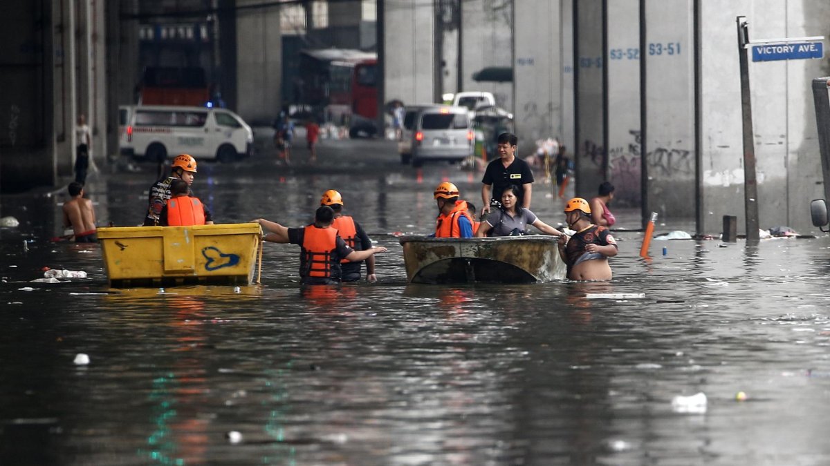 Los equipos de respuesta a emergencias utilizan balsas para ayudar a transportar a los residentes a lo largo de una carretera inundada en Filipinas.