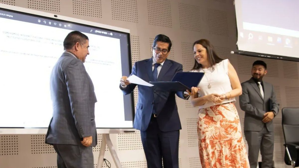 Los titulares del CES y de la Senescyt, Pablo Beltrán y Andrea Montalvo, entregan la respectiva resolución al representante de uno de los institutos.