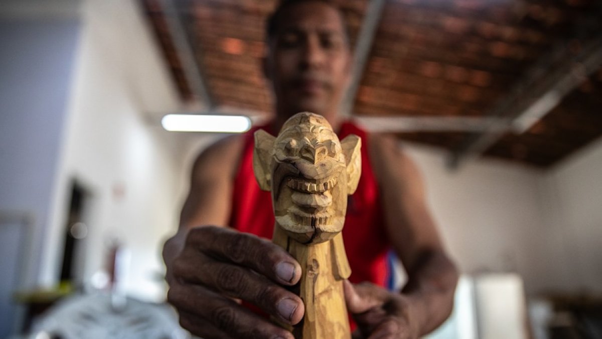 Oficio. El maestro Sandro esculpe una pequeña ‘carranca’, en su taller de artesanías ‘Maestro Quincas’.